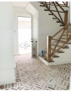 an empty room with brick flooring and stairs