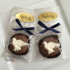 two chocolates wrapped in cellophane and decorated with white doves on them