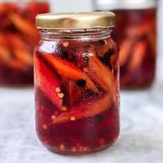 a jar filled with pickled vegetables sitting on top of a table