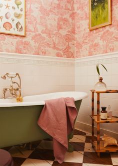 a bathroom with pink wallpaper and green bathtub in the corner, next to an old fashioned wooden shelf