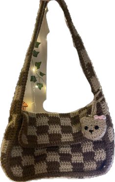 a crocheted purse with a cat on the front and small lights in the back