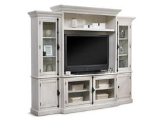 a white entertainment center with glass doors and shelves on each side, including a flat screen tv