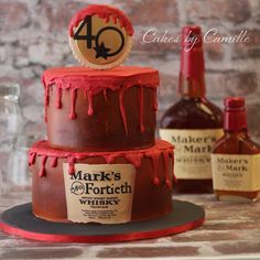 a three tiered cake with red icing and an old fashioned whiskey bottle on top