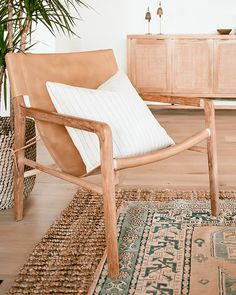 a wooden chair sitting next to a potted plant on top of a hard wood floor