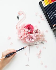 someone is painting flowers with colored pencils and watercolors on a white surface