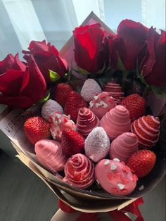 a bouquet of red roses and chocolate covered strawberries