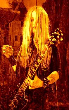 a woman with long blonde hair playing an electric guitar in front of a red background