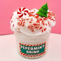 peppermint drink with whipped cream and candy canes in a cup on a table