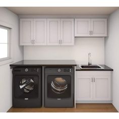 two washers and a dryer in a small room with white cabinets on the wall