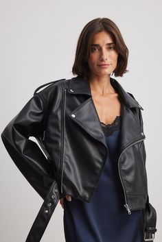 This jacket is made of PU and features a cropped oversized fit. It has a lapel neckline, a zipper detail on the chest and a strap detail at the shoulders. This jacket features wide long sleeves with a zipper on the cuffs, two side slanting zip pockets, a front zipper closure and an adjustable waistbelt. Lightweight Jacket Outfit, Borg Jacket, Womens Biker Jacket, Black Faux Leather Jacket, Denim And Lace, Spring Jackets, Future Fashion, Spring Looks, City Style