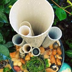 there are many pipes that are in the planter and it is all covered with rocks