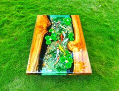 a wooden table with glass in it on the grass