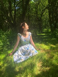 a woman sitting in the grass with her eyes closed