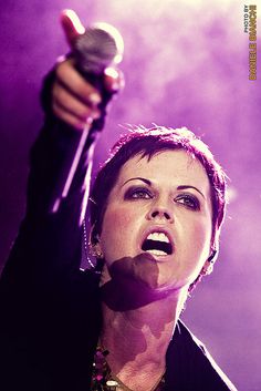 a woman holding a microphone in her right hand