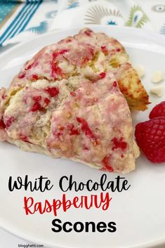 a white chocolate raspberry scones on a plate with some raspberries