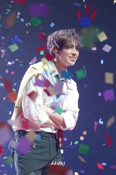 a young man standing in front of confetti