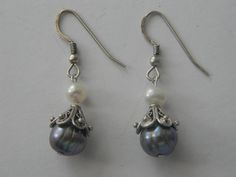 These elegant Victorian Style Genuine Gray & White Pearl Bridal Drop Hook Earrings are a beautiful addition to any jewelry collection. The intricate filigree cap design adds a touch of sophistication to these classic earrings. Perfect for any formal occasion, these earrings are sure to impress. Crafted with high-quality materials, these earrings are durable and long-lasting. The genuine gray and white pearls are a timeless combination, making these earrings a great choice for any bride. These ea Elegant Silver Earrings With Bead Caps, Traditional Wedding Jewelry With Bead Caps, Cap White, Classic Earrings, Pearl Bridal, Wedding Jewelry Earrings, White Bridal, Classic Jewelry, Bridal Pearls