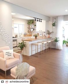 a living room filled with furniture next to a kitchen and dining room table covered in potted plants