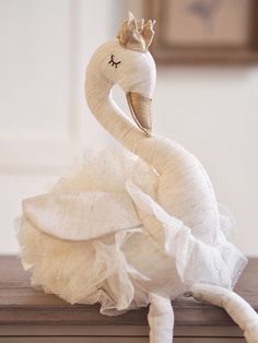 a white swan statue sitting on top of a wooden table