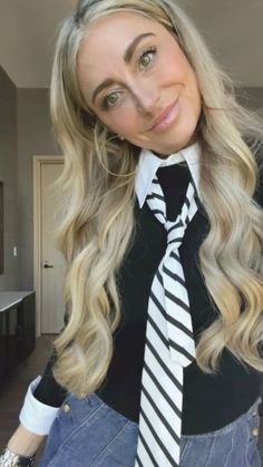 a woman with long blonde hair wearing a tie