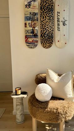 two skateboards mounted to the wall above a chair and table with pillows on it