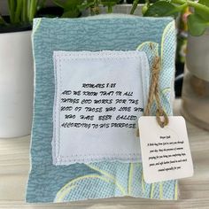 a blue and white frame with a poem on it next to a potted plant