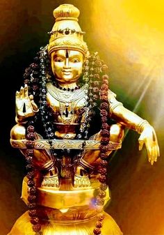 a golden statue sitting on top of a gold plate with beads around it's legs