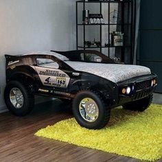 a black truck bed sitting on top of a hard wood floor next to a wall