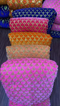 many different colored pillows stacked on top of each other