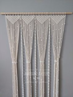 four white macrame curtains hanging on a wall