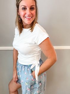 Elevate your everyday wardrobe with our White Side Tie Top! Made for comfort, this tee features a side drawstring detail and classic crew neck. Adjust the fit to your style and flatter your body with our unique women's t-shirt. Perfect for any occasion and a must have for warm weather. Fit is true to size. Emily is 5'8" wearing a medium. Small (0-4) Medium (6-8) Large (10-12) XL (14-16) Trendy Crew Neck Top With Drawstring, Cotton Drawstring Crew Neck Top, Cotton Crew Neck Top With Drawstring, Short Sleeve Drawstring Tops For Loungewear, White Cotton Top With Drawstring Tie, Summer Short Sleeve Tops With Drawstring Tie, Summer Tops With Drawstring Tie And Short Sleeves, Summer Tops With Short Sleeves And Drawstring Tie, White Cotton Tops With Drawstring Tie