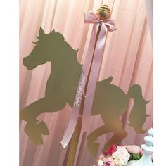 there is a cake topper with a horse on it next to a pink curtain