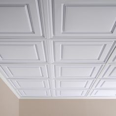 an empty room with white walls and ceiling tiles