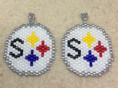 two white beaded earrings with yellow, red and blue crosses on the front side