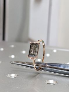 a diamond ring sitting on top of a pair of scissors