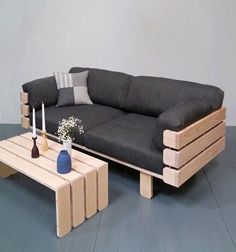 a couch and coffee table made out of wooden pallets on a blue painted floor