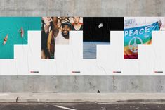 a man walking down the street past a wall with posters on it and people in different colors