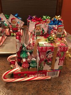 several wrapped presents sitting on top of a counter next to candy canes and candies