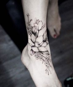 a woman's foot with a flower tattoo on it