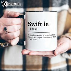 a person holding a coffee mug with the words swiffie in black on it