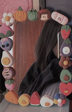 a woman is looking at herself in the mirror with buttons on her face and hair