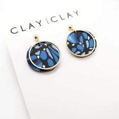 a pair of blue and black butterfly earrings