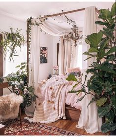 the bedroom is decorated in white and has plants growing on the bed, along with a chandelier