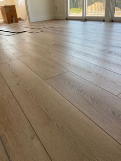 an empty room with hard wood flooring and sliding glass doors on the outside side