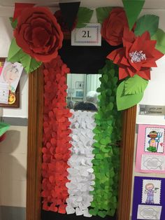 a classroom door decorated with paper flowers and greenery in the shape of an italian flag