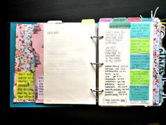 an open notebook with lots of colorful papers on it and some writing in the pages