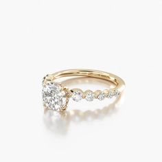 a yellow gold engagement ring with an oval cut diamond in the center and side stones