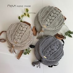 three crocheted bags sitting next to each other on a white surface with the words moly hand made written above them