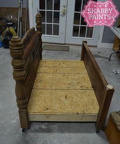 a wooden bed frame sitting in front of a door