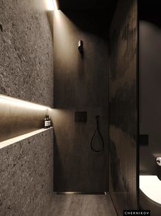 a bathroom with a toilet, sink and shower head light on the wall next to it